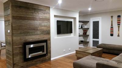 Timber feature wall in living room by Northern Rivers Recycled Timber - Brushed pipeline panels