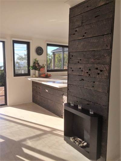 Timber feature wall in living room by Northern Rivers Recycled Timber - Choc Washed Sleeper panels