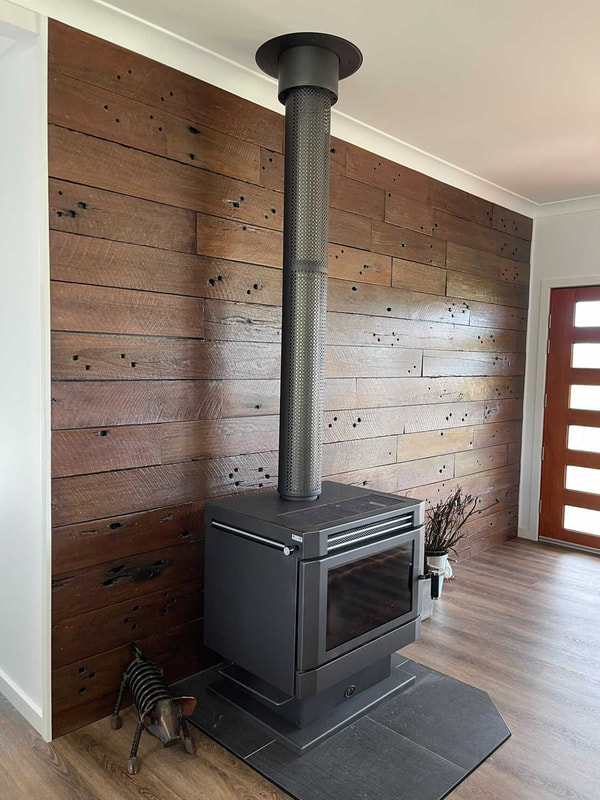 Recycled timber wall behind fireplacePicture